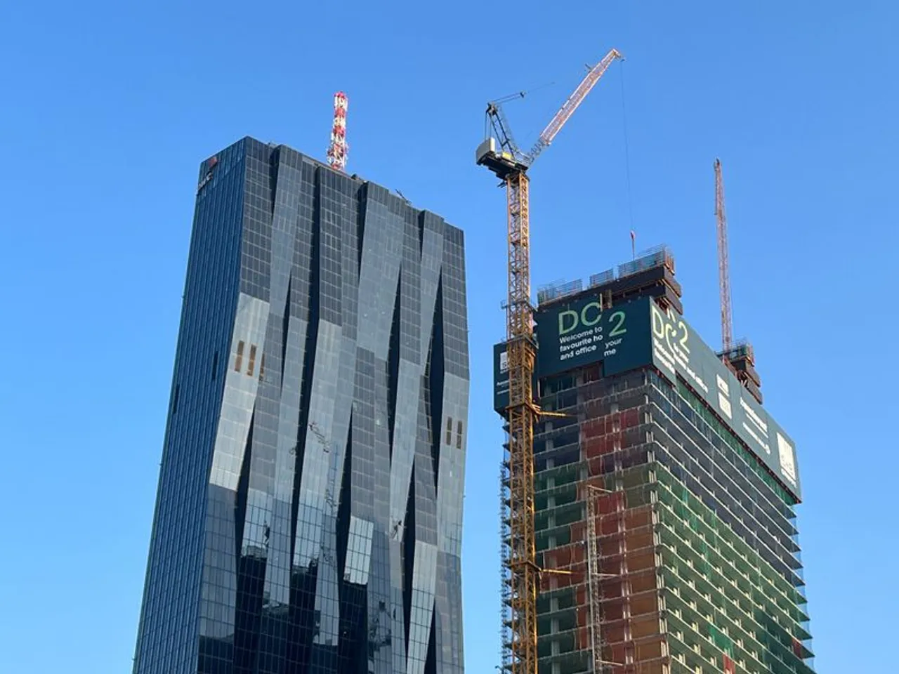 Der DC Tower 2 wächst, ein Roboter hilft beim Bau mit